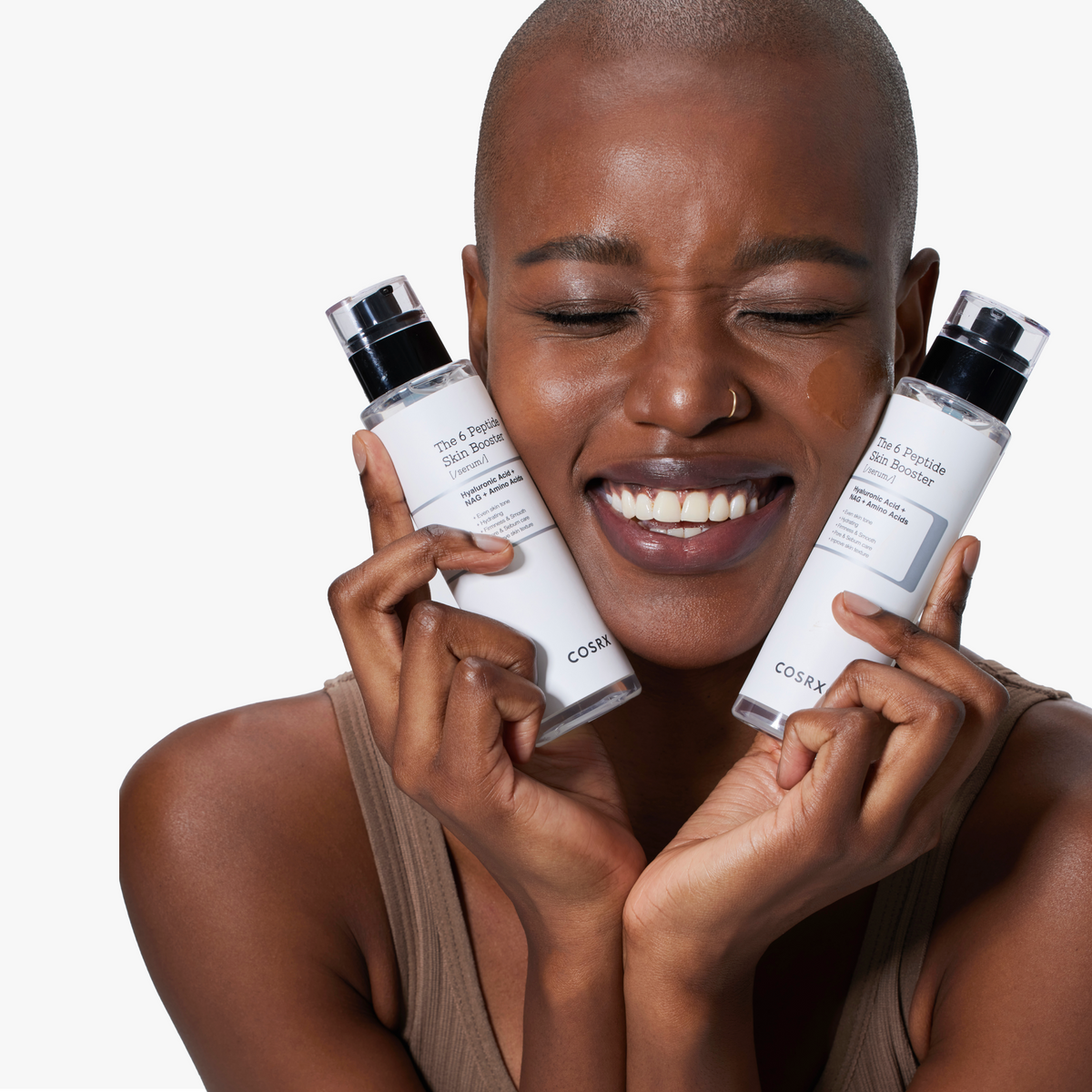 Smiling model holding two bottles of COSRX The 6 Peptide Skin Booster Serum close to her face; radiant skin illustrating the hydrating, firming, and glow-enhancing benefits of the Korean first-step all-in-one peptide serum formulated for sensitive skin and barrier repair.