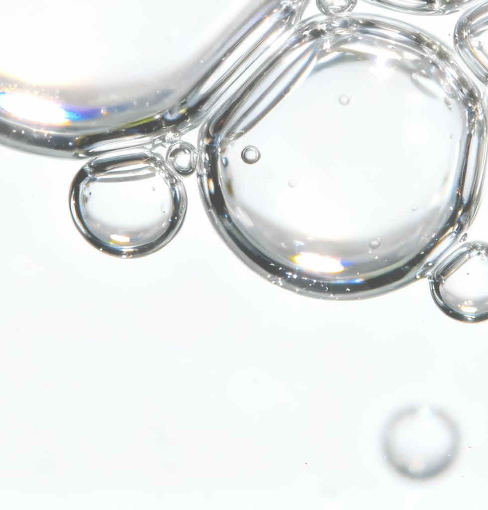 Macro view of clear serum droplets representing hyaluronic acid and betaine in COSRX Advanced Snail 96 Mucin Power Essence; formula provides long-lasting hydration and plump smoothness, enhancing the skin’s firmness and radiance over time.
