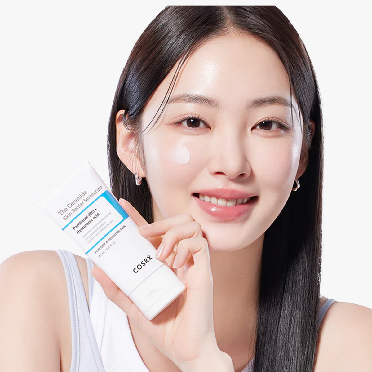 Model holding COSRX The Ceramide Skin Barrier Moisturizer and showing applied product on cheek; dermatologist-tested Korean moisturizer with Ceramides, Cholesterol, Fatty Acids, Panthenol (B5), and 5 types of Hyaluronic Acid that provides deep, lasting hydration and barrier protection. Designed for sensitive and dry skin, absorbs well under foundation without heaviness.