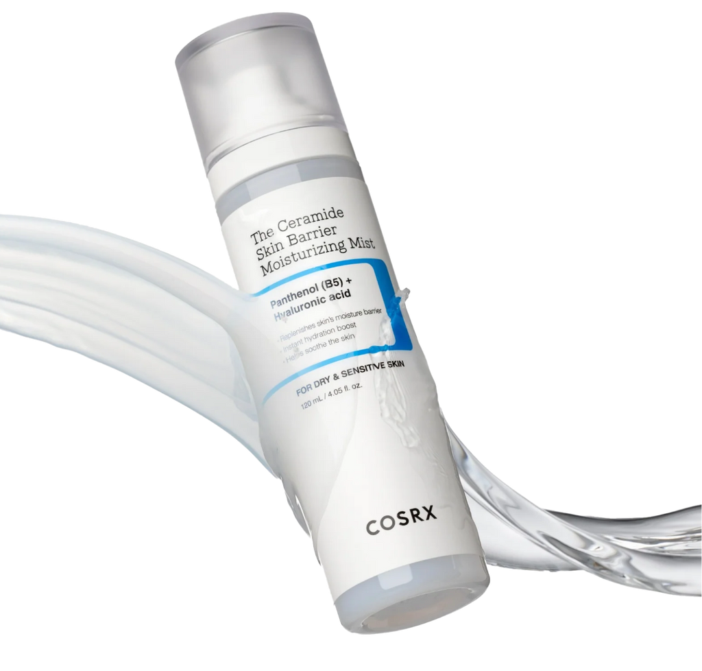COSRX The Ceramide Skin Barrier Moisturizing Mist bottle shown with flowing creamy mist texture; showcases Panthenol (B5) and Hyaluronic Acid formula that delivers soft, milky hydration to reinforce the moisture barrier and calm sensitive, dehydrated skin.
