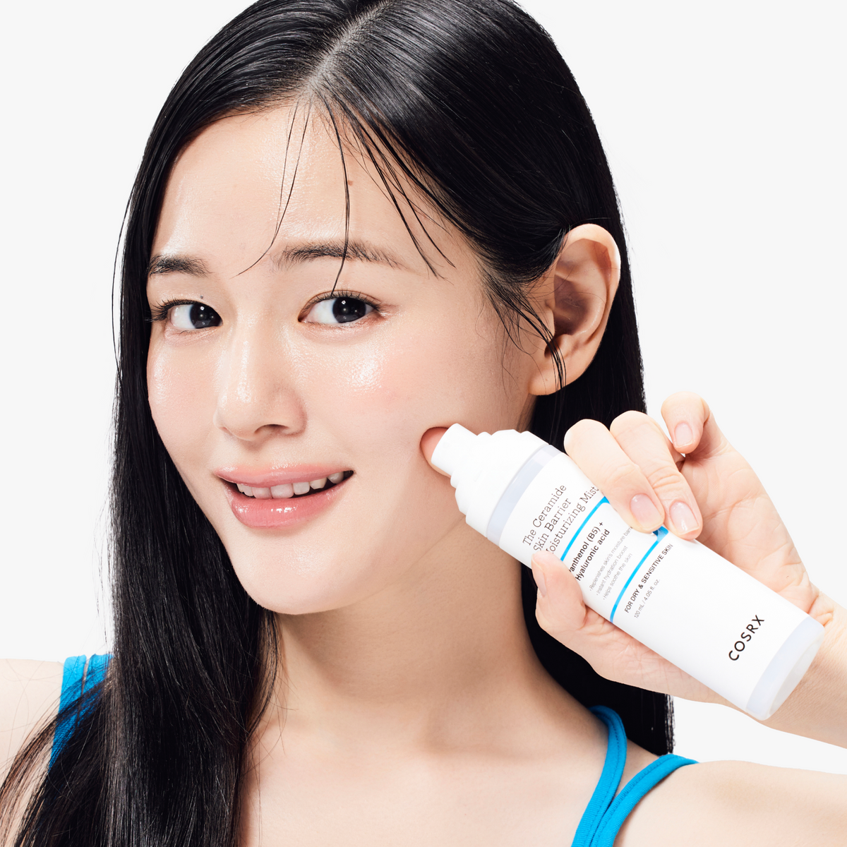 Model smiling while holding COSRX The Ceramide Skin Barrier Moisturizing Mist close to the face; highlights the ultra-fine, lightweight formula that instantly replenishes hydration and reinforces the skin barrier, clinically proven to soothe redness and irritation by 81.1% after one use, ideal for daily care of sensitive or stressed skin.